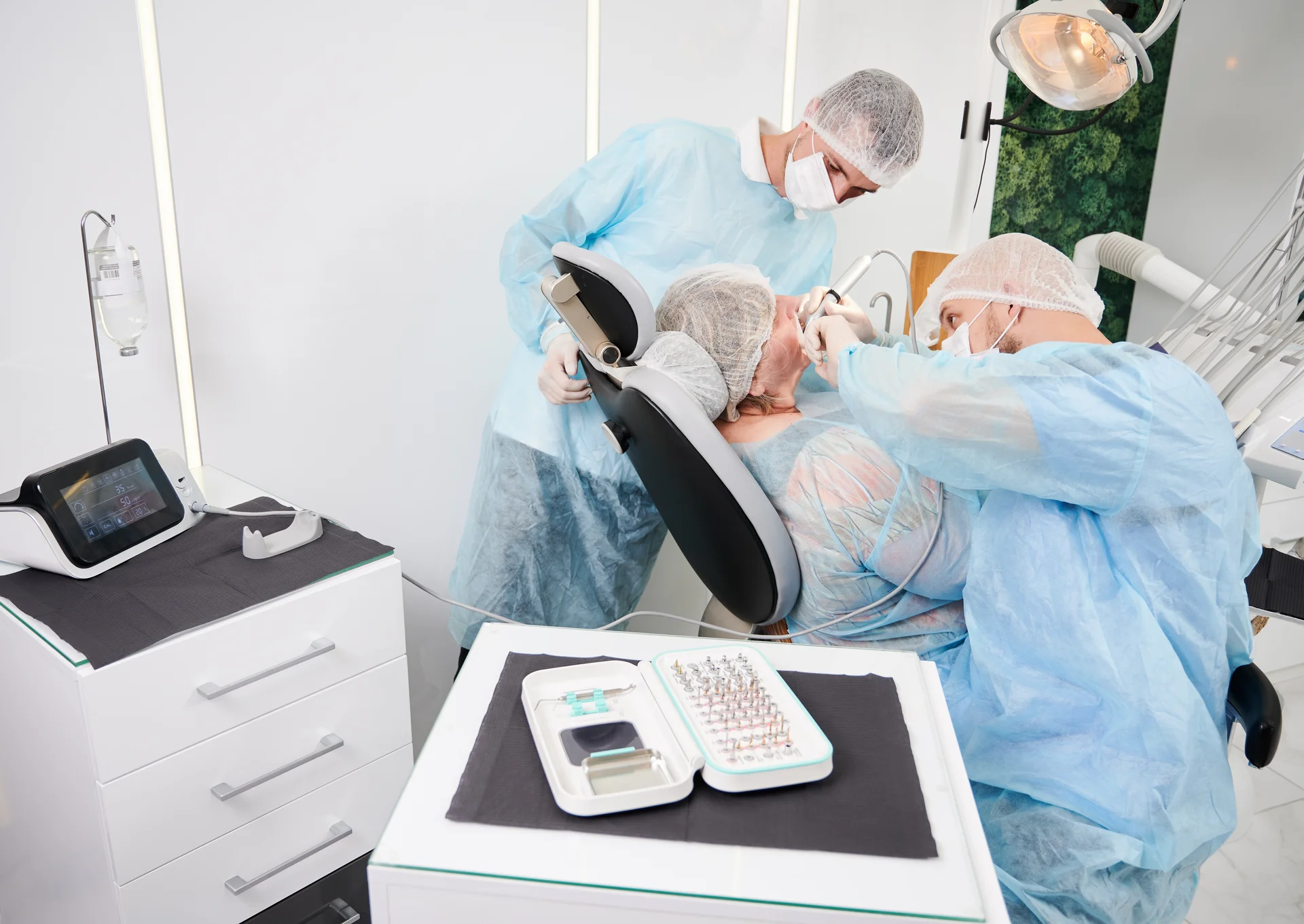 Zahnarzt fuehrt All-on-4 Implantation mit modernem Equipment durch